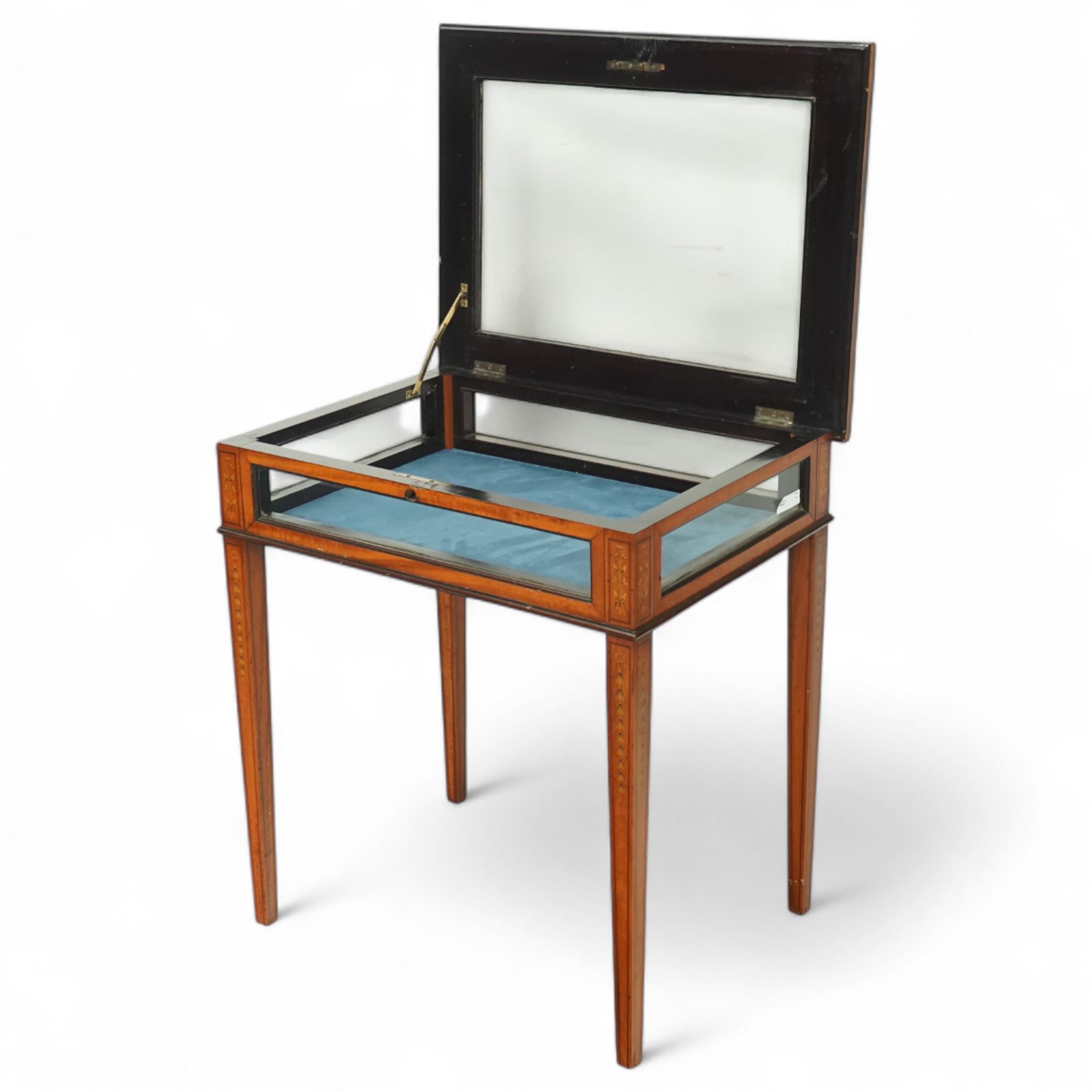 Edwardian satinwood bijouterie table, rectangular glazed top and glazed sides enclosing a blue velvet-lined display well, raised on square tapering legs, decorated throughout with neoclassical foliate inlay