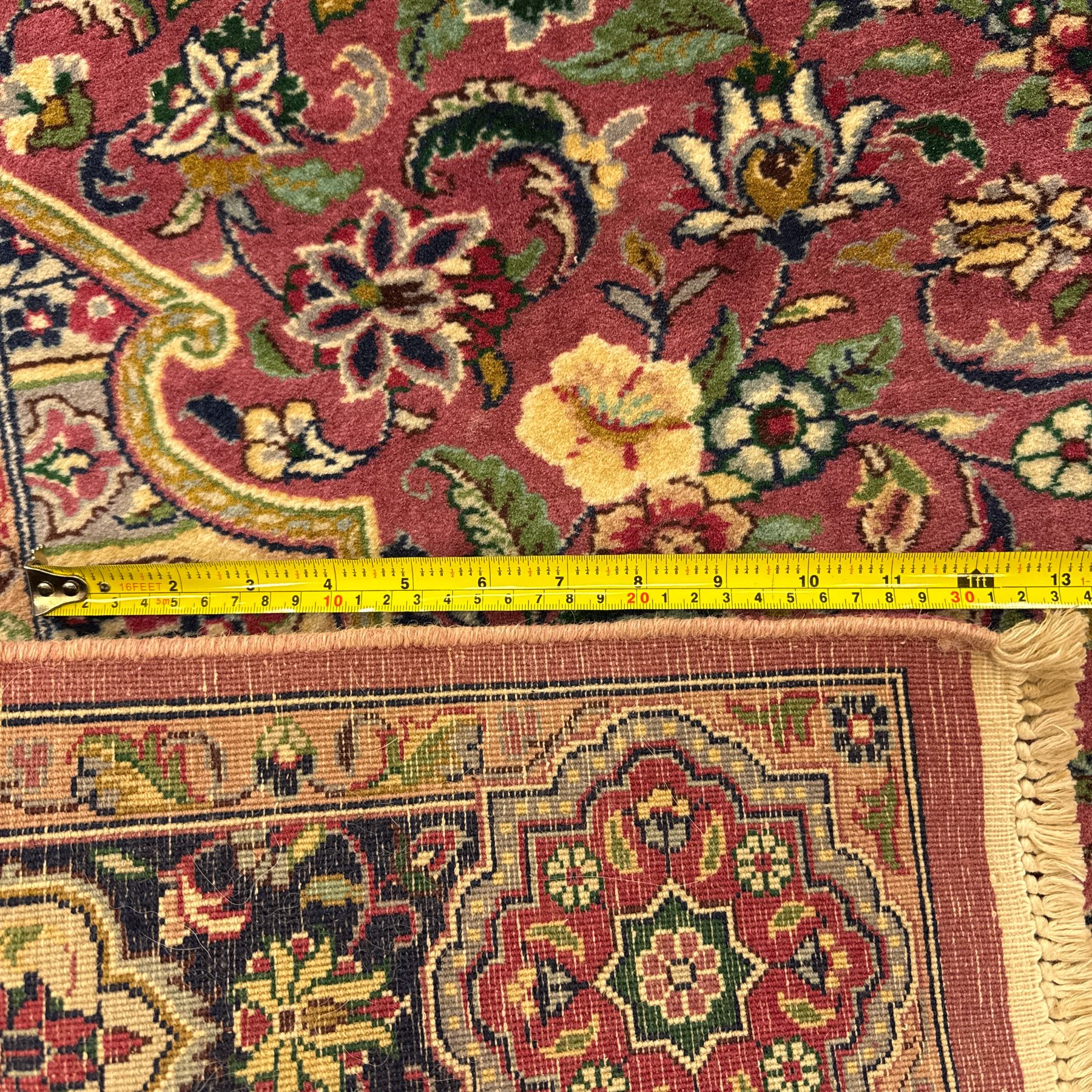 Kashan design hand knotted wool carpet, decorated with an ivory and green floral medallion on a pink ground with scrolling vines, ivory spandrels, multiple navy and ivory borders with stylised flowerheads, from the region of Punjab, Pakistan