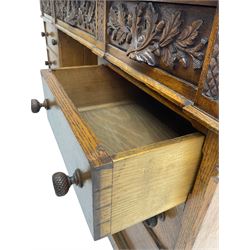 Late 19th century heavily carved oak twin pedestal desk, rectangular top with two raised trinket or correspondence structures each with three drawers, rectangular top over three frieze drawers carved with acorn and oak leaf decoration, each pedestal with three drawers with acorn husk shaped handles