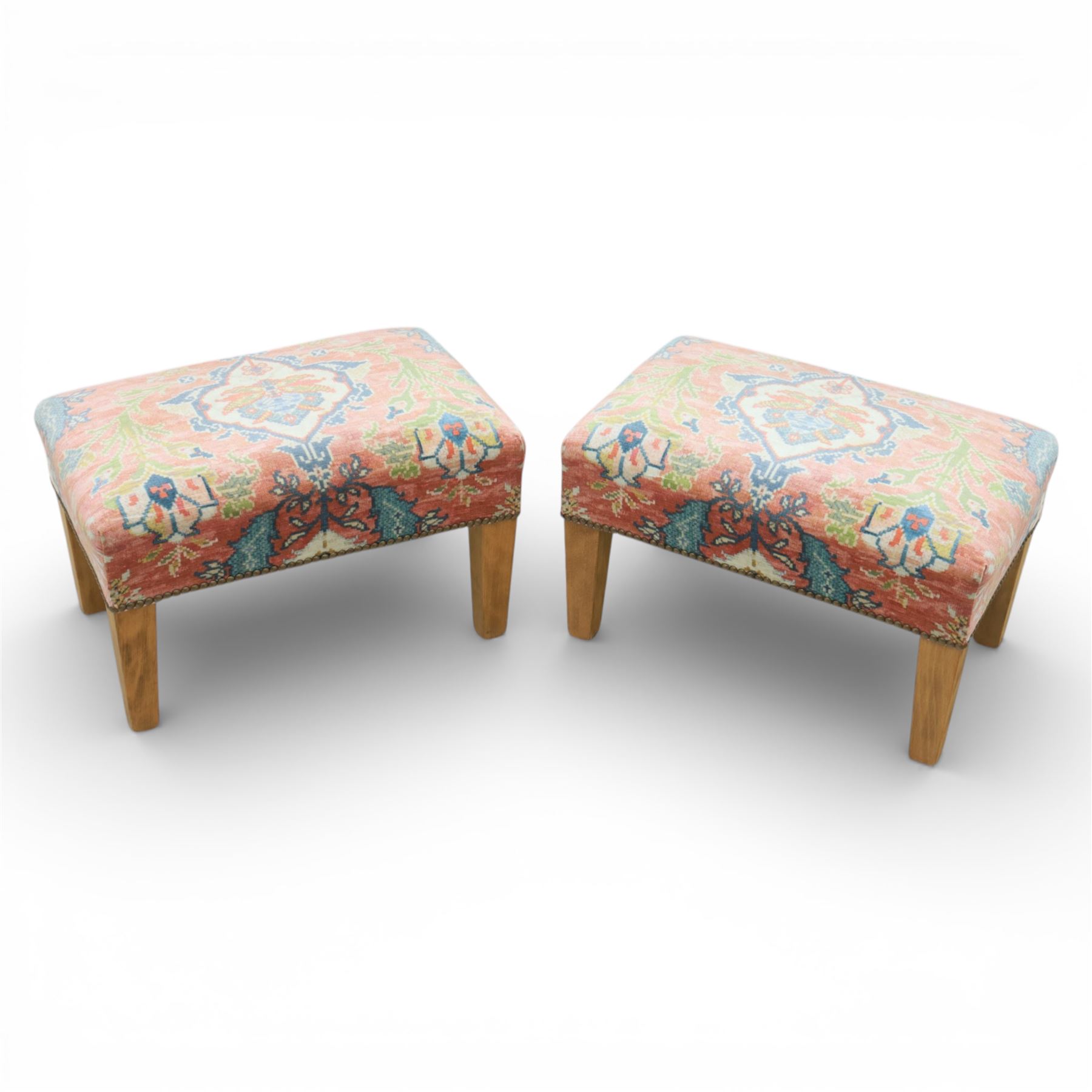Pair of needlepoint footstools, retailed by The Bespoke Footstool Co, brass studded trim on tapered oak supports