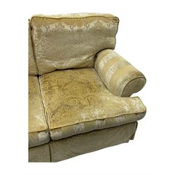 Contemporary two-seat sofa, upholstered in damask fabric with a pale gold floral pattern, rolled arms with covers, loose back and seat cushions, on matching skirted base with concealed castors