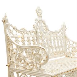 Victorian revival heavy cast iron garden bench, ornate back rest with scrolls, floral motifs and central crest, pierced lattice seat, curved arms and decorative legs, painted in antique white, in the Gothic Coalbrookdale style