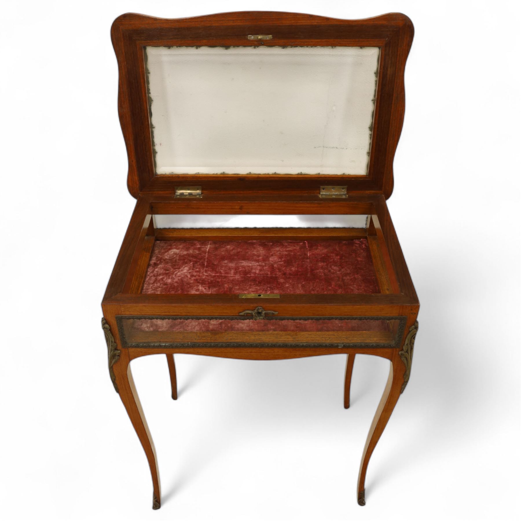 Louis XV revival style walnut bijouterie table, rectangular serpentine form, with brass edging and a hinged floral marquetry inlaid lid with bevelled glass top and sides, gilt-bronze beaded border, interior lined with rich red velvet, raised on slender cabriole legs with gilt bronze masks and sabots, circa 1900