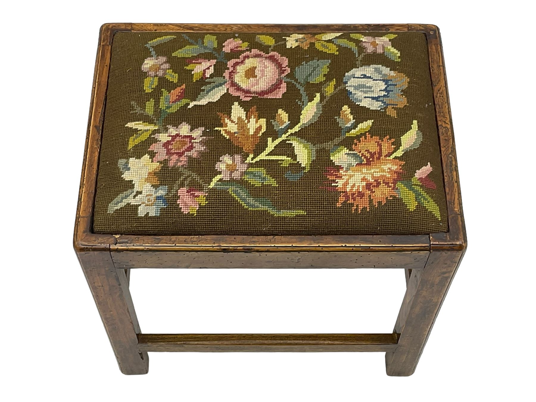 20th century mahogany rectangular footstool, needlework upholstered drop-in seat, on ball and claw carved feet (W81cm, D35cm, H34cm); 19th century elm stool, needlework upholstered drop-in seat, on square moulded supports united by plain stretchers (W45cm); 19th century walnut stool, shaped top upholstered in needlework, on cabriole supports (W50cm); 19th century rosewood stool, upholstered drop-in seat, on curved x-framed supports united by turned stretcher (W47cm)