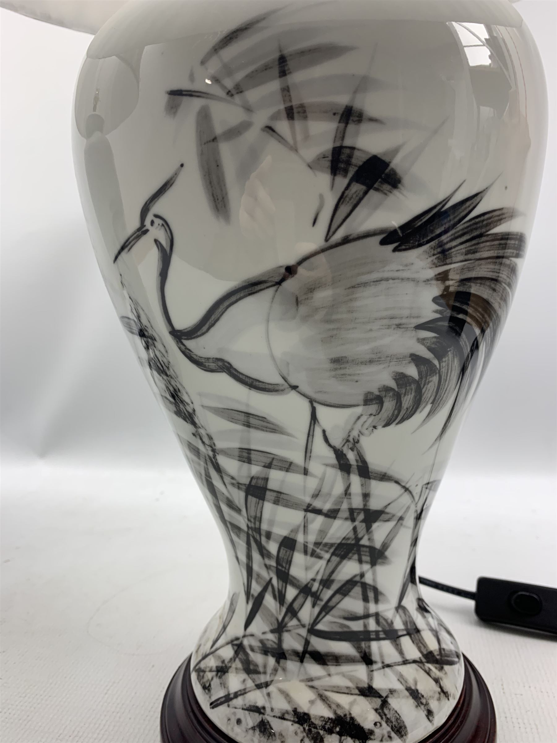 Pair of Chinese porcelain table lamps, each of inverted baluster form, decorated with wading Herons amongst reeds against a plain ground, raised upon circular hardwood base, H66cm including shade 