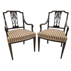 Edwardian mahogany framed three-piece salon suite - two-seat sofa, stepped cresting rail over acanthus and scroll carved pierced splat, upholstered in striped fabric (W124cm, H87cm, D62cm); and a pair of matching armchairs (W60cm) 