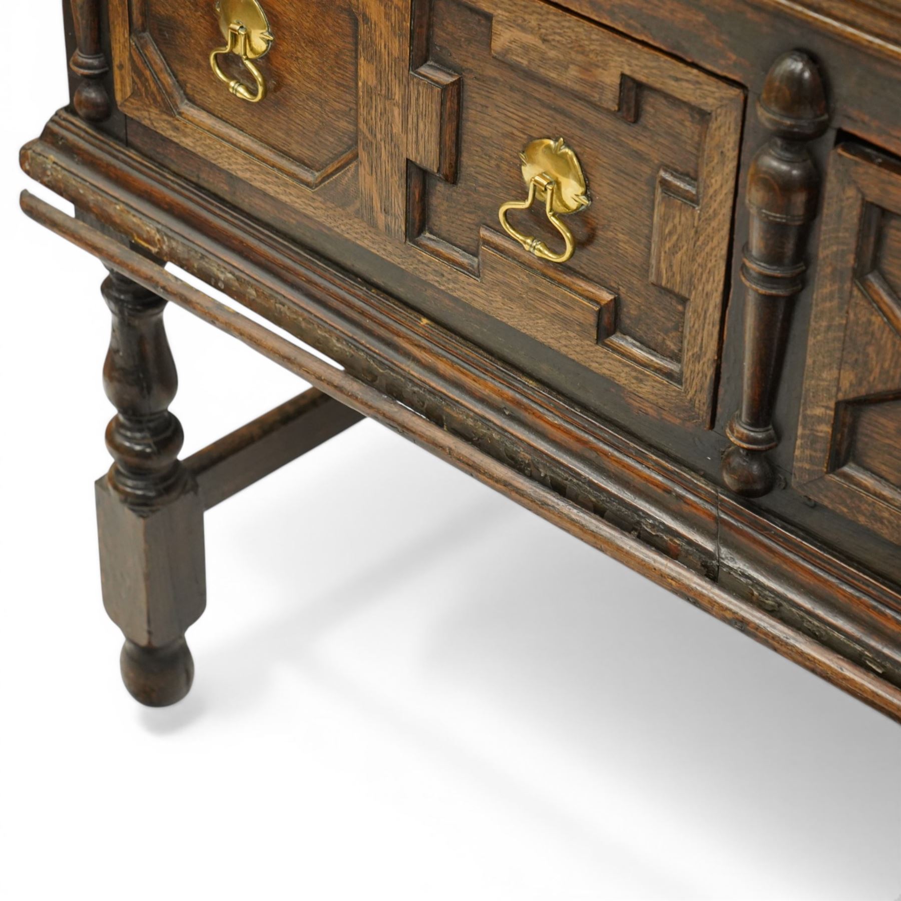 19th century Jacobean Revival oak dresser and rack, the upper section with open shelves and central cupboard, flanked by bobbin moulded uprights, the base fitted with three carved drawers with brass ring handles, raised on turned supports united by stretchers