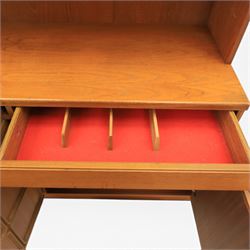 Mid-20th century teak wall display unit, featuring two glazed cupboards and fall front compartment with open shelves, above three drawers and cupboards to the base