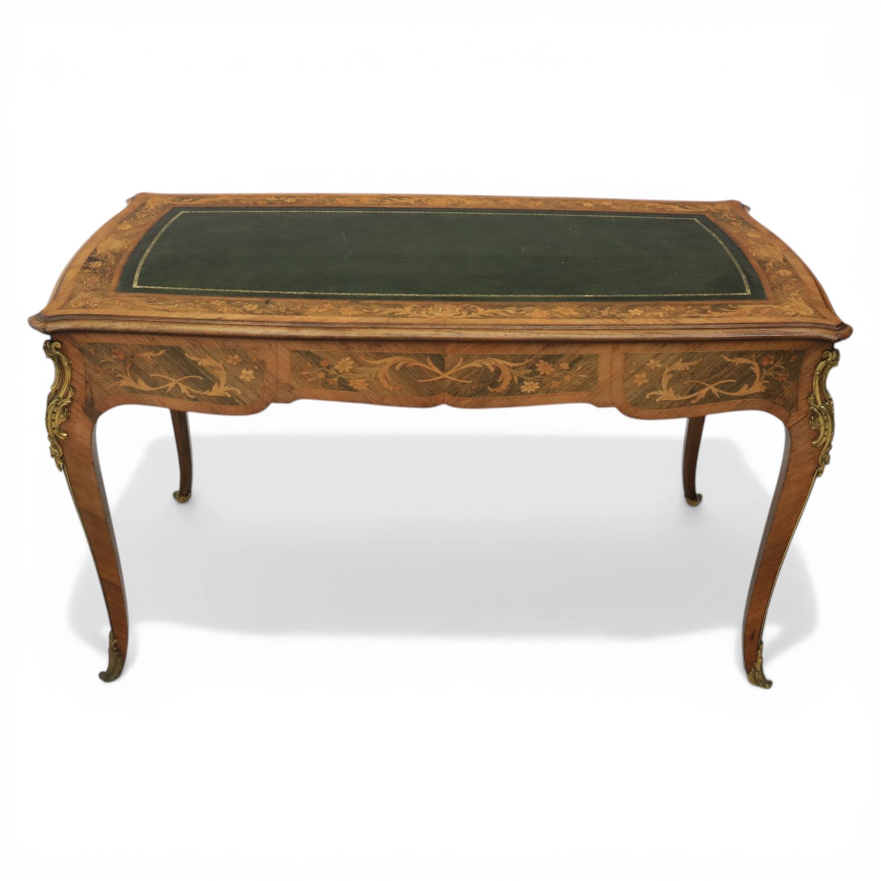 Late 19th century French kingwood and marquetry bureau plat, the serpentine rectangular top with green leather inset writing surface within crossbanded and foliate marquetry border, above a shaped frieze fitted with three drawers with floral marquetry panels and gilt metal handles, upon cabriole supports with applied gilt metal mounts and sabots