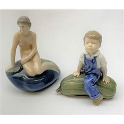  A Royal Copenhagen figurine, modelled as a mermaid, H13.5cm, together with another figure modelled as a boy seated upon marrow, H12cm, each with printed and painted marks to base.   