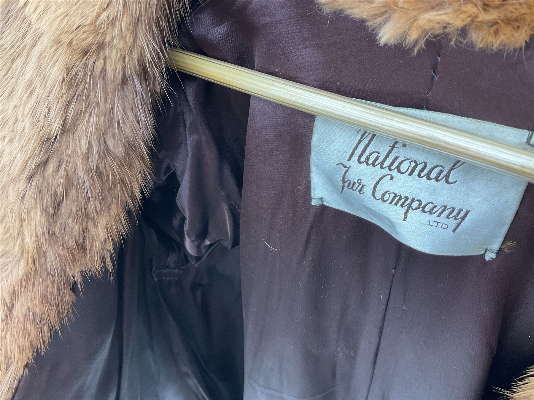 Brown mid length musquash fur coat by National Fur Company together with white rabbit cape