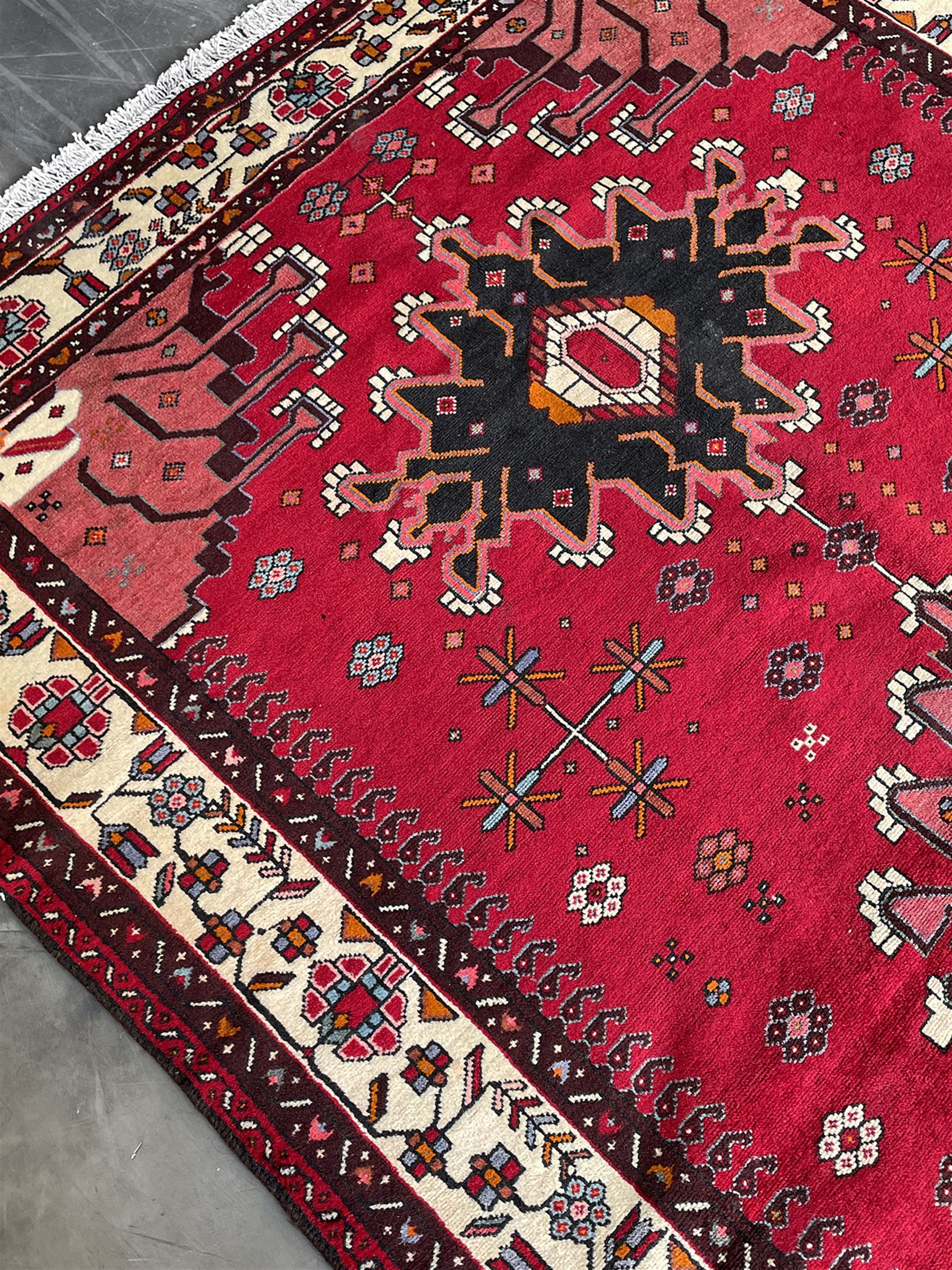 Persian Hamandan rug, the red ground field decorated with triple medallions and stylised motifs
