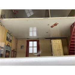Mid-20th century Mettoy tin-plate double-fronted two-storey doll's house, the front elevation with five unglazed windows flanked by green shutters, central opening door, open back giving access to five rooms together with an attached garage, 60cm wide