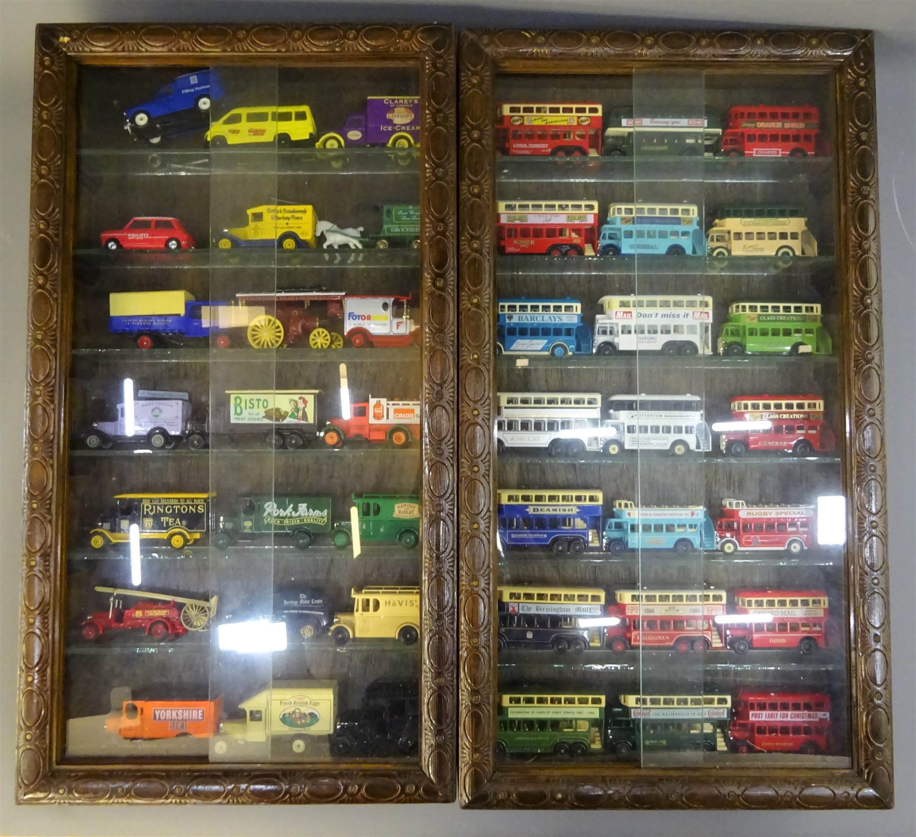 Pair Of Stained Wooden Wall Mounting Die Cast Display Cabinets Each With Carved Frame And Pair Of Sliding Glass Doors Enclosing Glass Shelves And Total Of Forty Two Lledo Days Gone And Promotional Ve