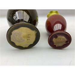 Linthorpe pottery vase with crimped rim and ovoid body, Linthorpe jug with high loop handle and crimped spout, a pair of candlesticks with a green, brown glaze and other similar pottery 