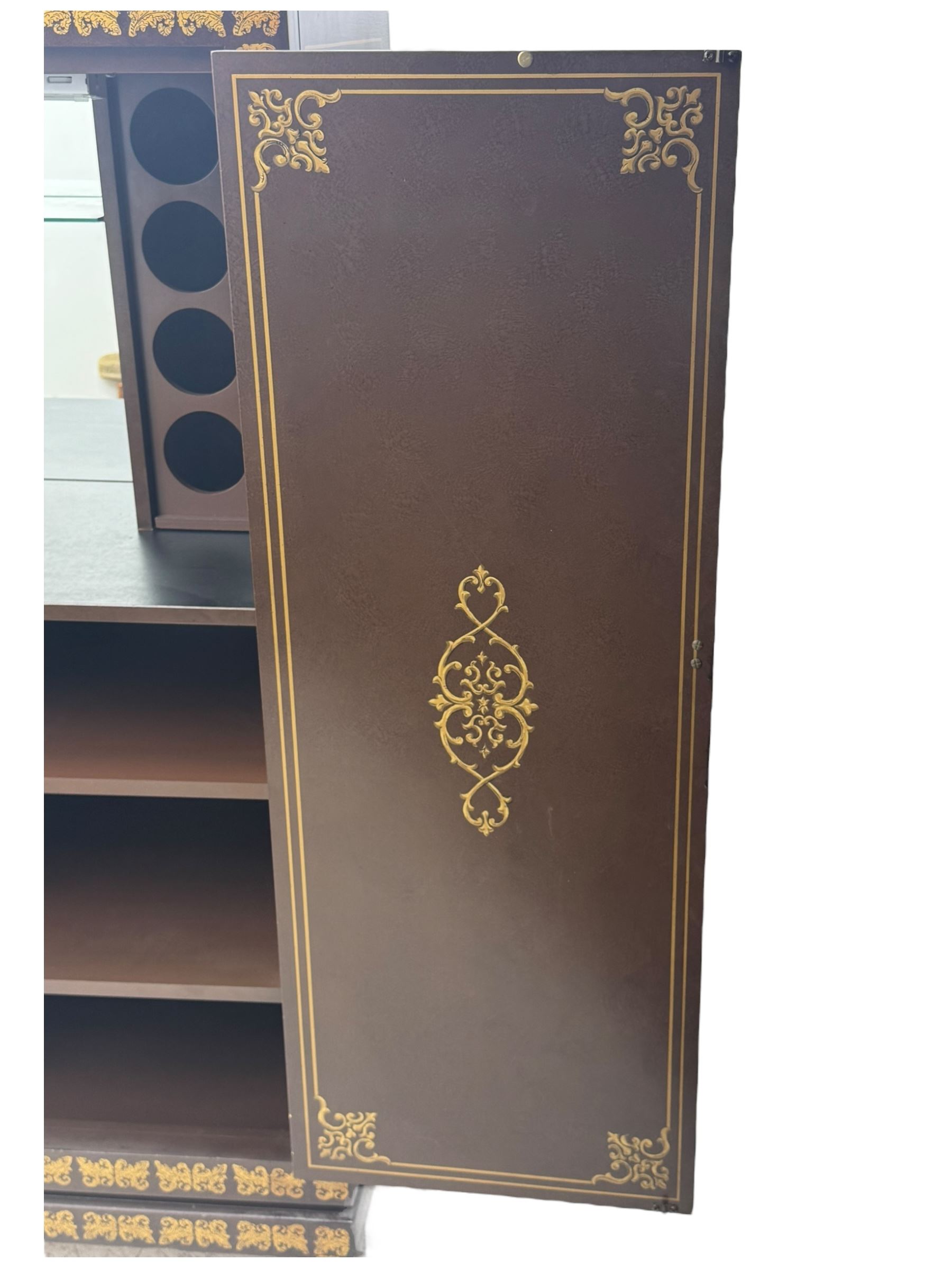 Chinese brown lacquered cocktail cabinet, decorated with gilt scenes of a traditional landscape with figures, pagodas, and mountainous scenery, double doors opening to reveal fitted interior with mirrored back, wine rack, shelves and cupboard, raised on square supports