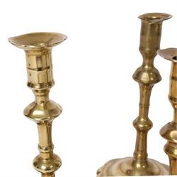 pair of 18th century brass candlesticks, each having slender knopped stems and scalloped petal base, together with two other brass candlesticks, H21cm