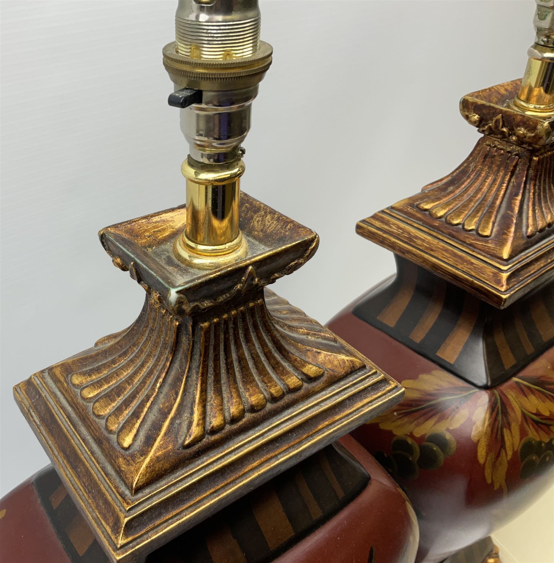 Pair Oriental table lamps decorated with birds in a tree with fruit, on a red ground with a gilded base together with cream lampshades H57cm, without lampshade. 