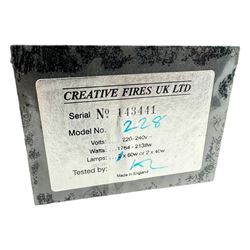 Stained glass and cast iron electric fireplace, arched top with decorative finials, stained glass front panel with floral motifs, flanked by cast iron scrolls, raised on scroll supports