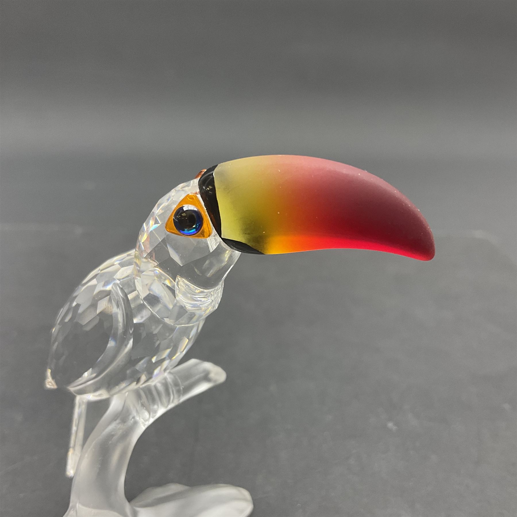 Three Swarovski Crystal bird figures, comprising Toucan, pair of puffins and pair of parrots on a branch, tallest H10cm