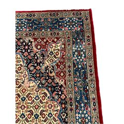 Persian Moud carpet, the field decorated all-over with Herati motifs, central medallion and spandrels decorated with stylised plant and flower head motifs, repeating border with guard