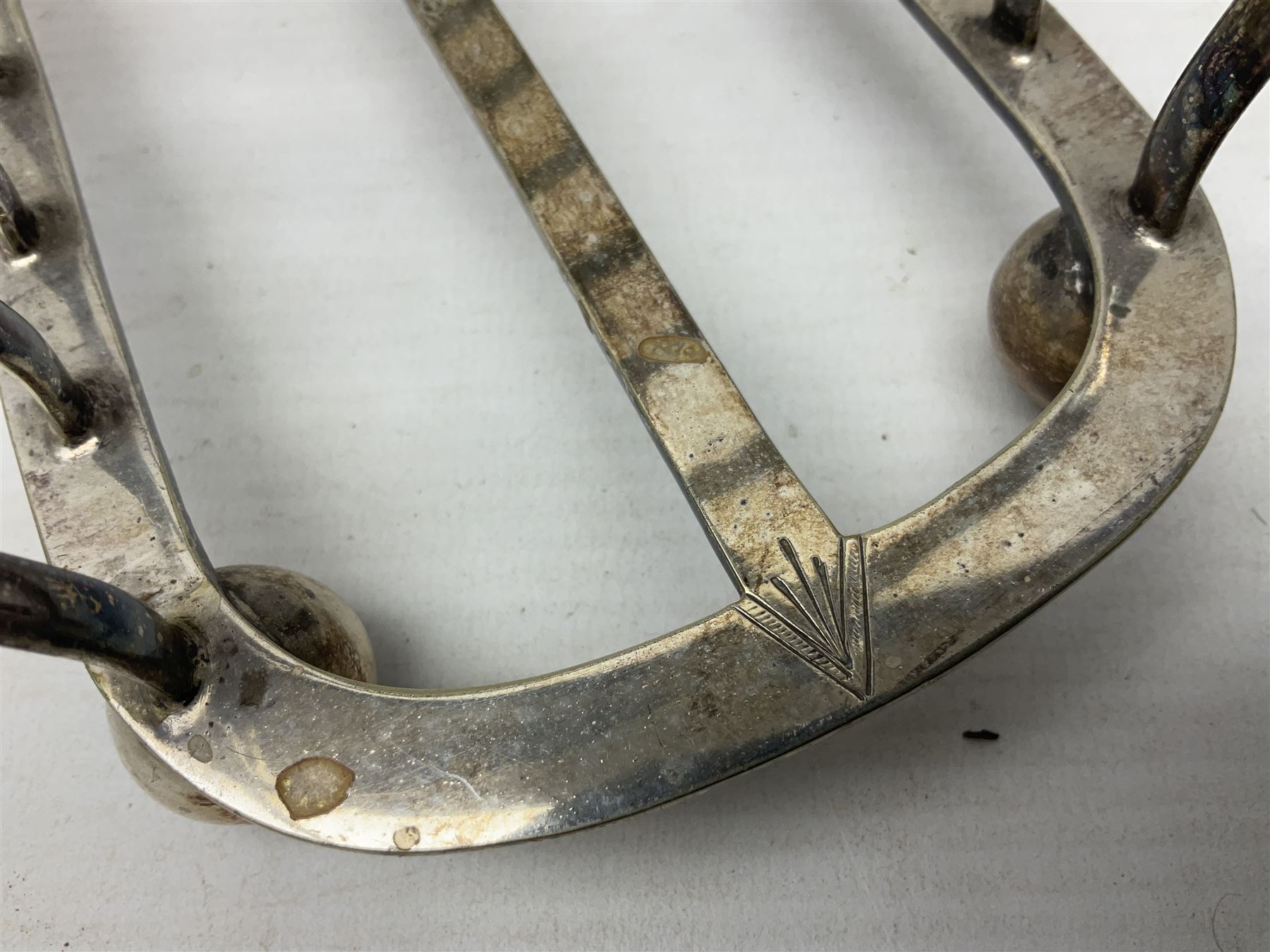 Silver plate seven bar toast rack, of curved form with central ring handle, upon bun feet, H13cm 