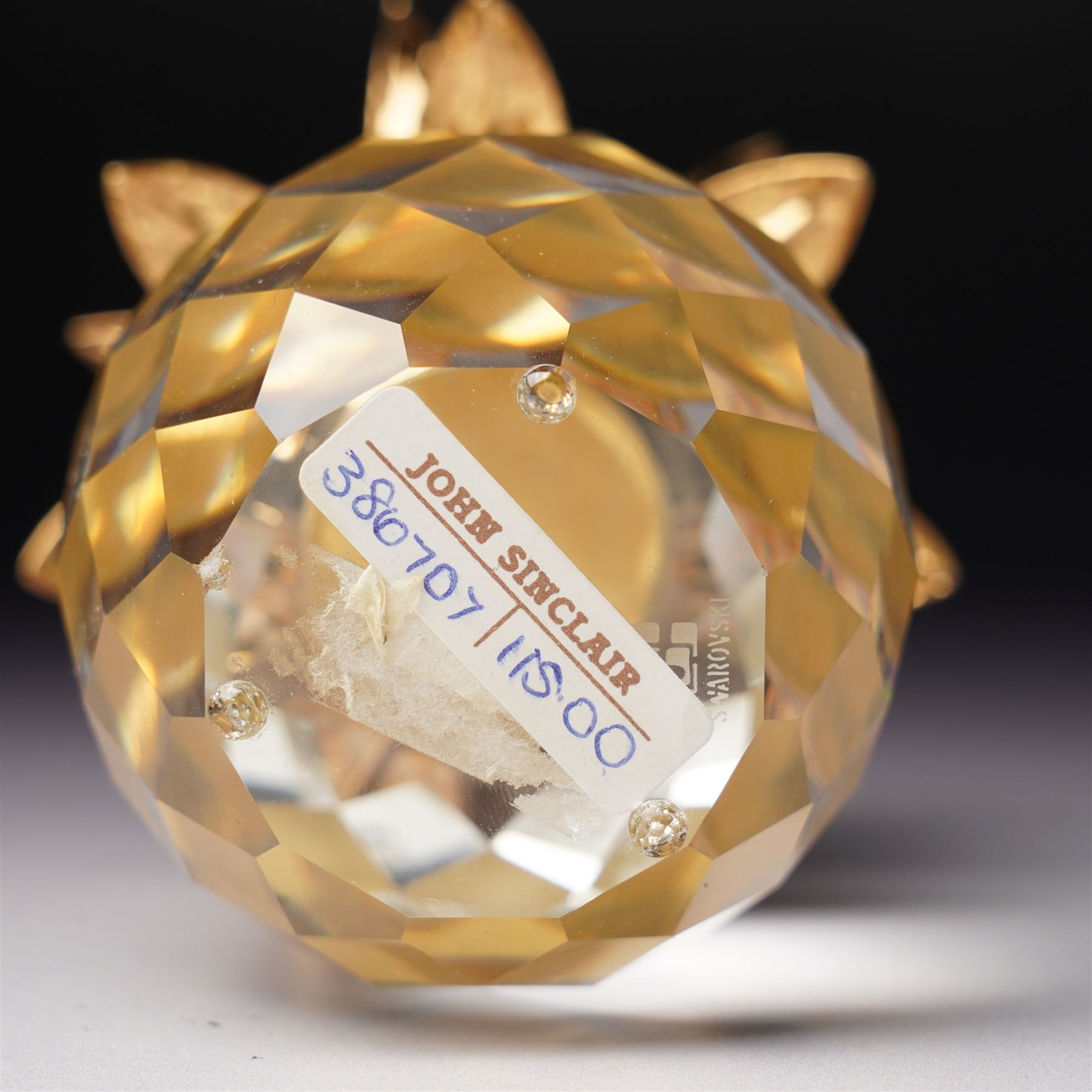 Pair of Swarovski Crystal candlesticks, boxed, together with two paperweights in the form of pineapples with gilt mounts, a large and small example, boxed (4)
