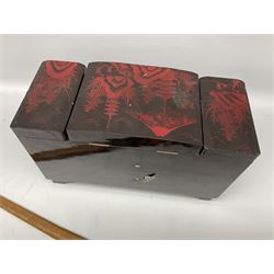 Oriental lacquered jewellery box, the body decorated with a black and red mountainous riverscape enclosing a glass compartment with simulated ivory rickshaw figure and three hinged lids opening to reveal mirror and various compartments and painted ceremonial stick