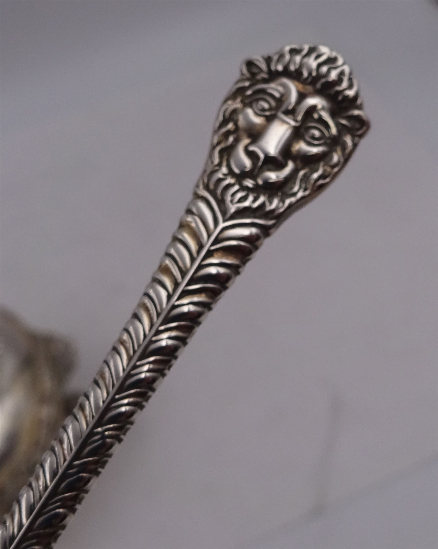 Early 20th century silver open sucrier, of circular form, with fluted gadrooned rim and decorated in relief with floral swags, united by three lion mask mounts and upon three paw feet, hallmarked Z Barraclough & Sons, London 1912, H6cm, D11cm, with similar spoon with lion mask finial, hallmarked London 1912, maker's mark indistinct