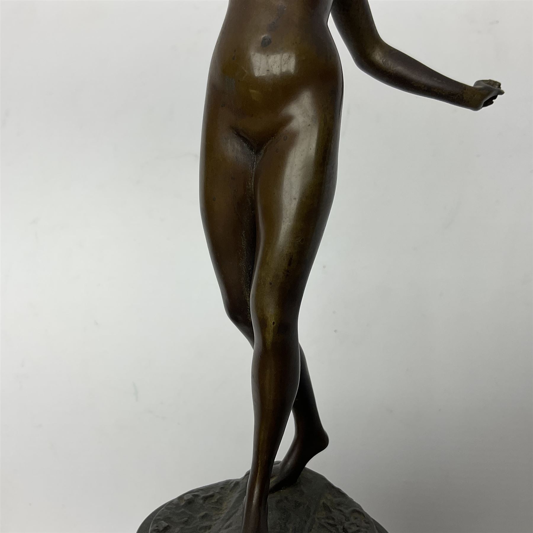 Bronze figure modelled as a nude woman with one arm raised a crescent moon upon her forehead, raised upon a circular stepped plinth, H36cm