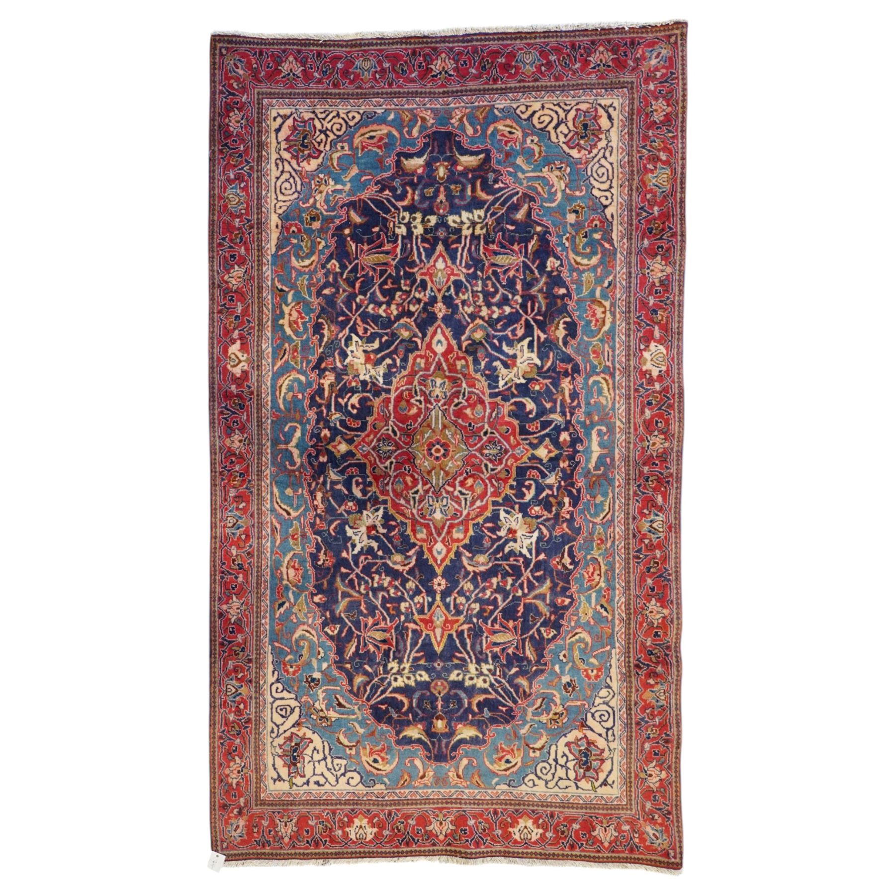 North West Persian Sarouk hand-knotted rug, indigo field with central stepped medallion with pendants, issuing an all-over arrangement of scrolling vinery, palmettes and stylized floral sprays, enclosed by a broad turquoise field of sinuous arabesques,, ivory spandrels with foliate decoration, madder red main border of stylized palmettes, and flowering vines, flanked by reciprocal guard stripes, cotton fringe ends 