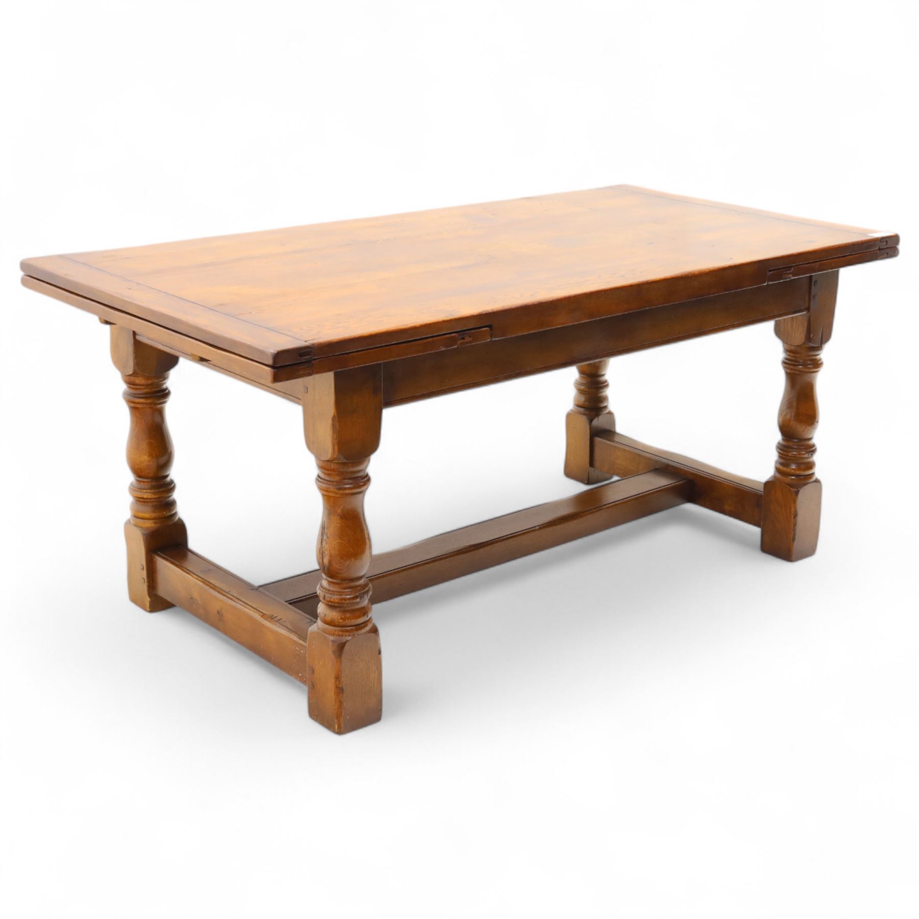 20th-century good quality solid oak extending refectory table, planked, constructed rectangular top with two extending leaves on the underside above a plain frieze raised on four turned baluster supports united by stretchers on block feet, 260cm extended