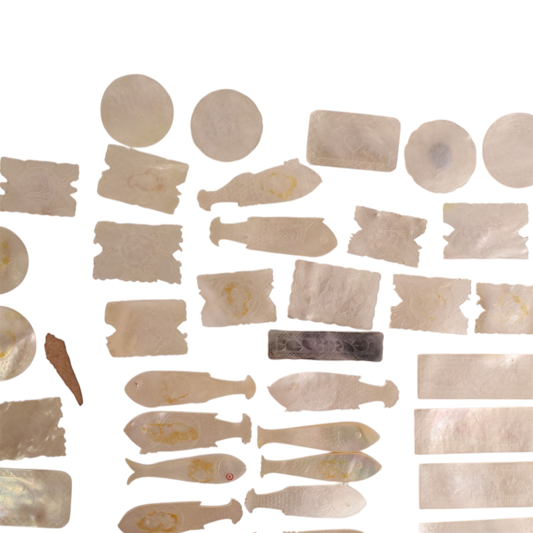 Collection of approximately sixty mother-of-pearl gaming tokens, including fish-shaped, rectangular, circular examples 