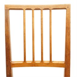 Acornman - set of four oak dining chairs, chamfered slatted back, tan leather drop in seat, raised on square supports with carved acorn signature, by the workshop of Alan Grainger of Brandsby