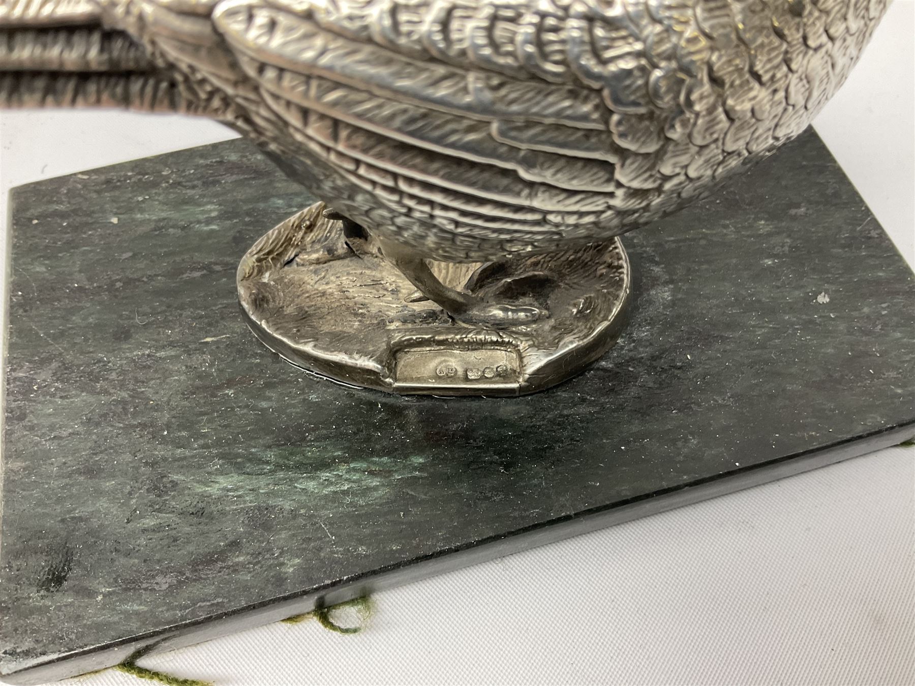 Group of silver, to include filled figure of a pheasant, hallmarked for London, pair of silver mounted horn napkin rings, miniature Edwardian bible with silver cover embossed with putti, Victorian silver brooch, ebonised plinth with applied inscribed silver shields, etc., together with two stick pins, one example with 9ct gold terminal 