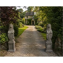 Pair of cast stone Heraldic lions, modelling in upright standing poses with flowing mane, ...