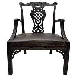 Early 20th century Chippendale design mahogany elbow chair, possibly Irish, the cresting rail carved with extending and scrolled acanthus leaves, shaped and pierced splat carved with further acanthus leaves and scrolls with shell carved lower rail, the arms with foliage carved terminals on shaped supports decorated with flower head carvings, wide-seat upholstered in brown leather with stud work, the square chamfered supports carved with flower heads and strap-work, with pierced corner brackets 