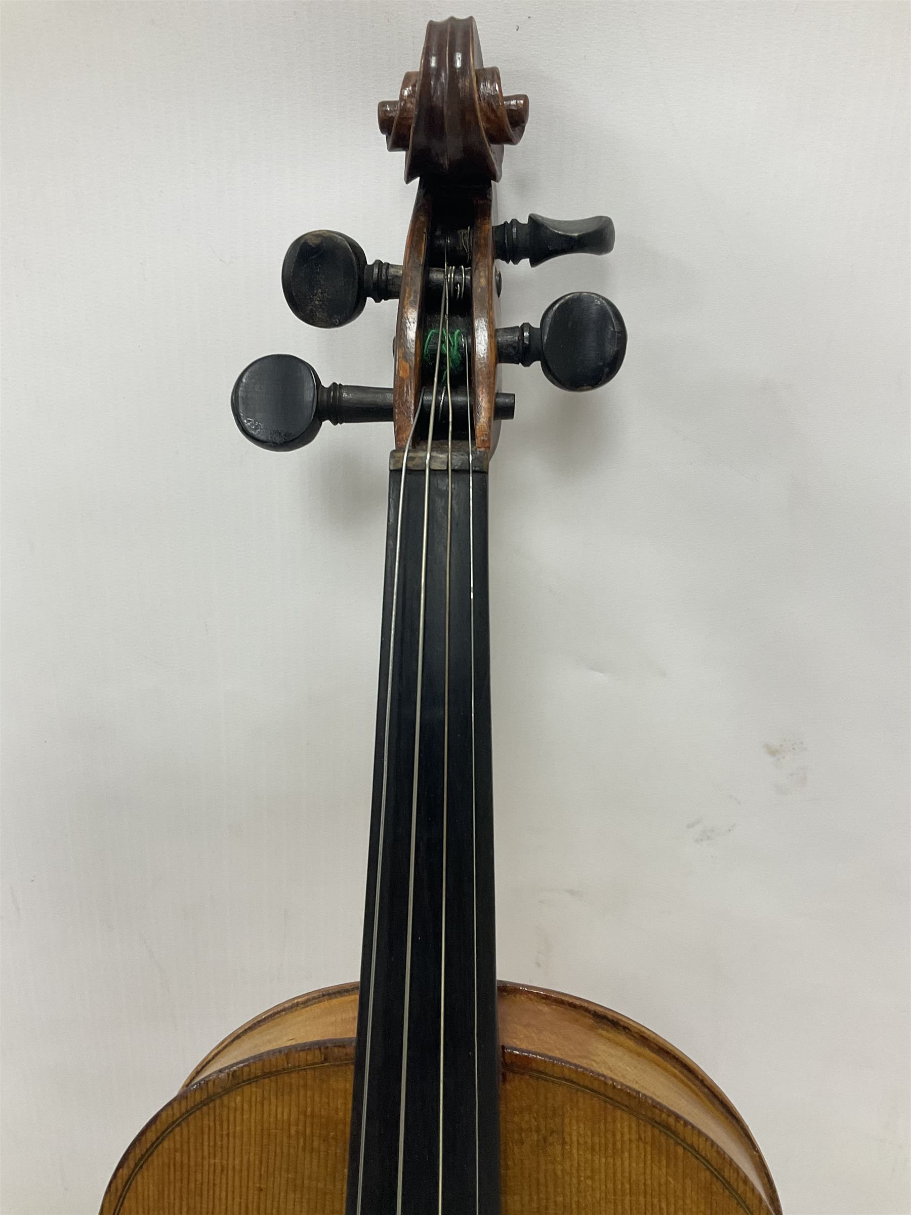 Copy of a full size Stradivarius violin, with an ebonised fretboard, tailpiece and tuning pegs, with a polished chin rest  Length 60cm