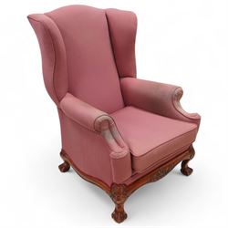 Georgian design mahogany framed wingback armchair, upholstered in rouge fabric, on ball and claw feet with foliate cartouche decoration 