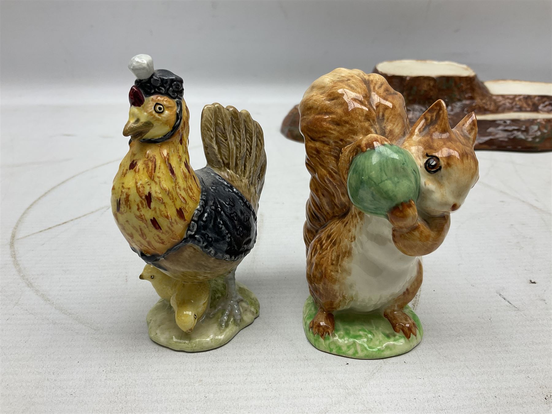 Seven Beswick Beatrix Potter figures, comprising Sally Henny Penny, Johnny Town-Mouse, Mrs Tiggy-Winkle, Mrs Tittlemouse, Tom Kitten, Pig-Wig and Squirrel Nutkin, together with a Beswick tree trunk display stand, stand L30cm