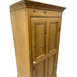 Waxed pine narrow wardrobe/cupboard, fitted with single panelled door, above single drawer