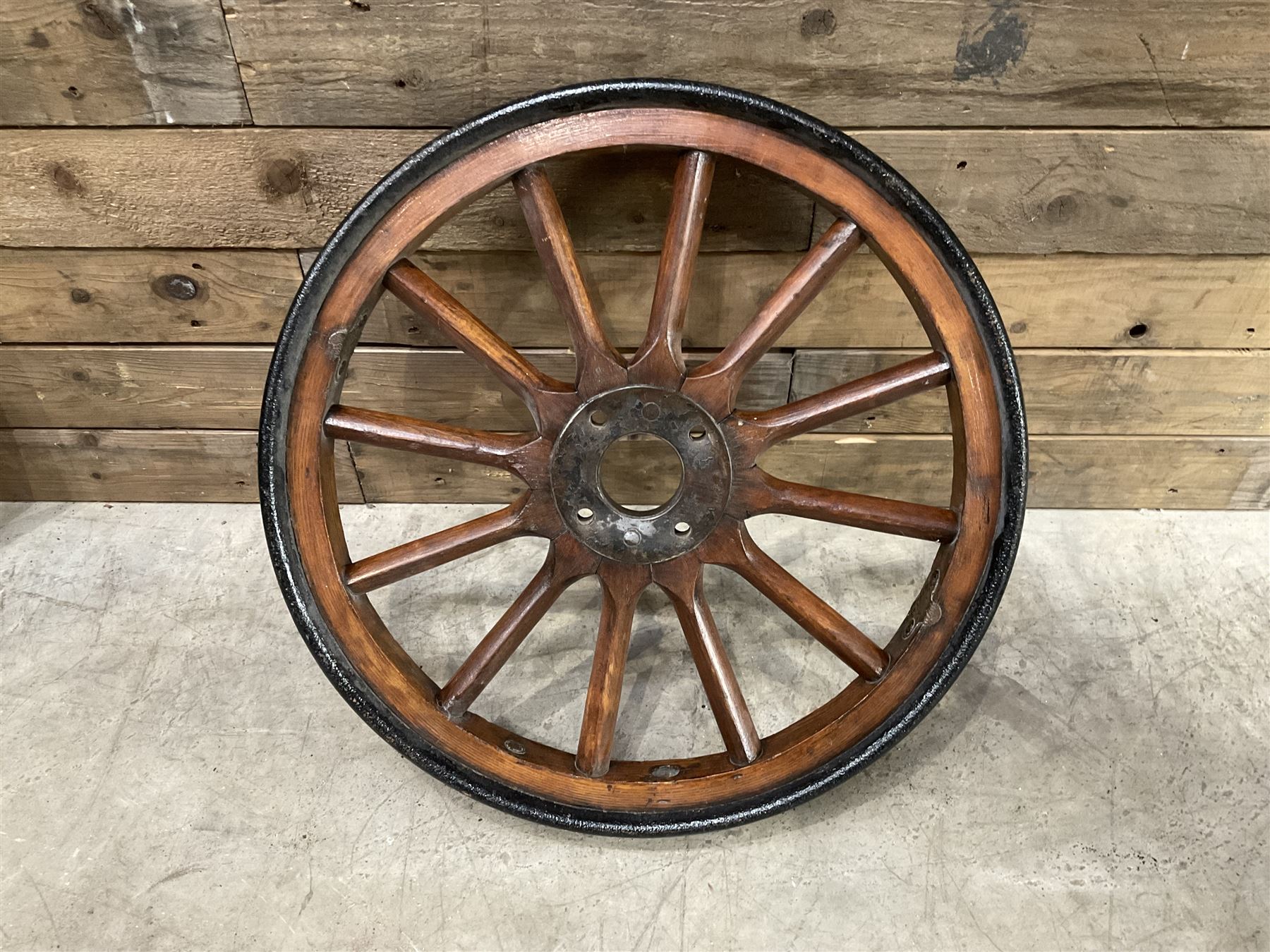 Set of four wheels from an early 20th century cart, wood with metal outer