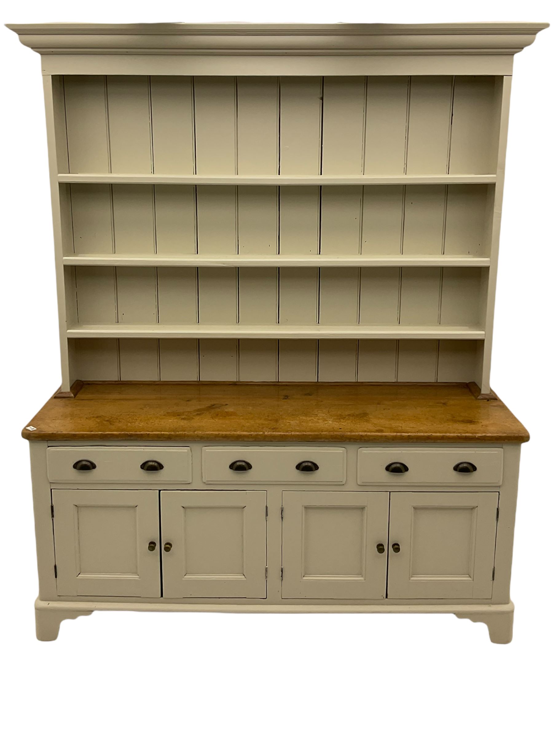 Victorian pine dresser, raised painted three heights plate rack with projecting cornice, waxed top over pained base fitted with three drawers and two double cupboards, bracket feet