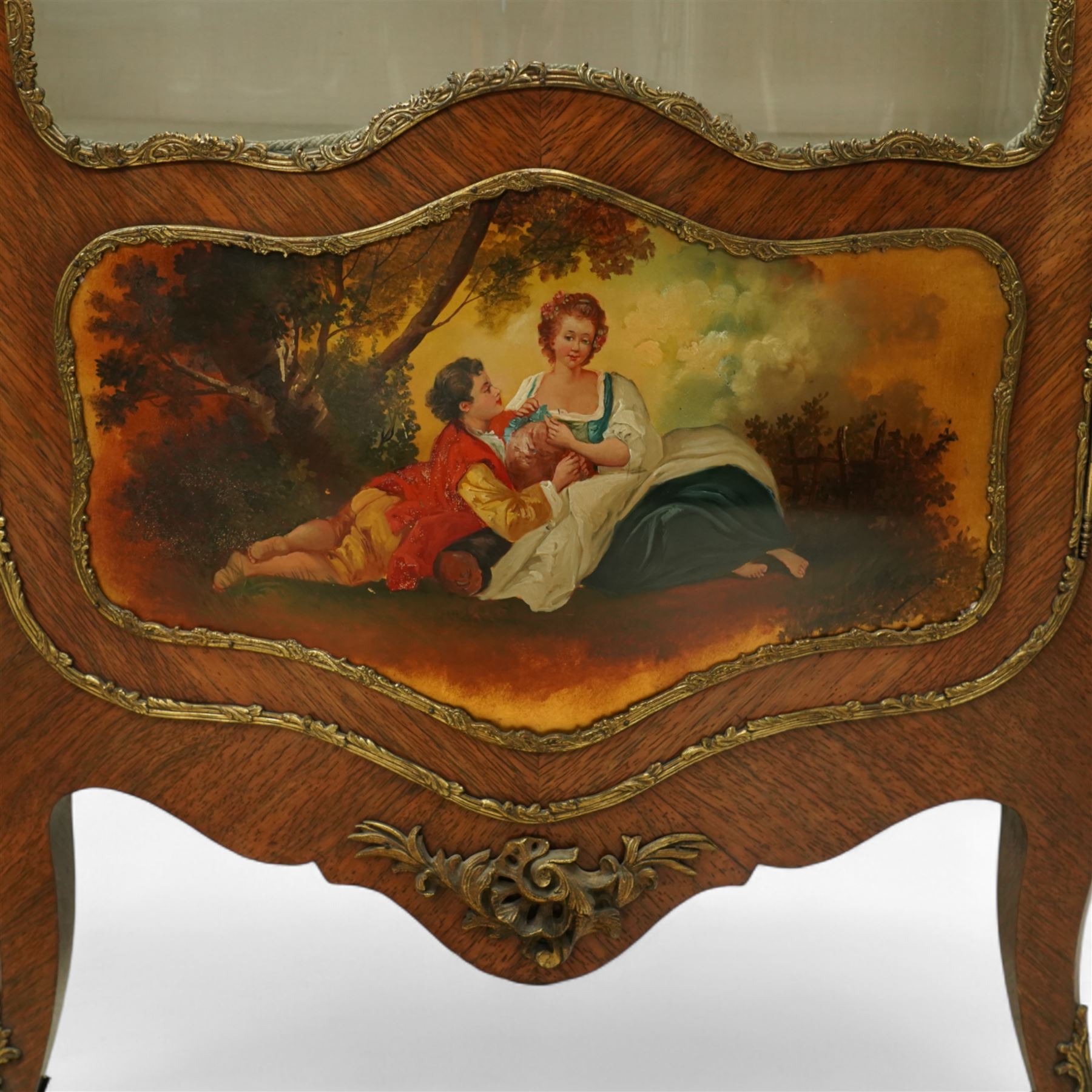 Louis XV revival kingwood Vernis-Martin serpentine fronted vitrine cabinet, arched top with gilt brass foliate mounts, glazed door with two shelves above three painted panels, depicting pastoral scenes, supported on out-swept cabriole legs with gilt brass mounts and sabots.