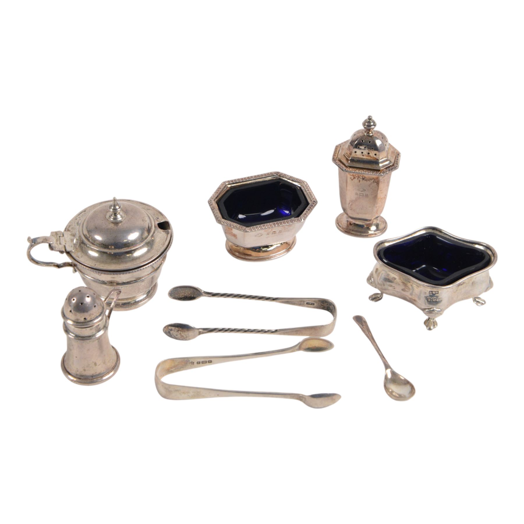 Collection of silver cruet items and flatware, including miniature muffineer, two pairs of sugar tongs, mustard pot and cover, open salts and pepper shaker, all hallmarked