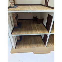 1:24 scale stone effect three-storey cottage dolls house, with green arched door and lattice effect windows, decorated to the interior with wooden floors, wired lighting and fire places, H45cm, W57cm, D26cm