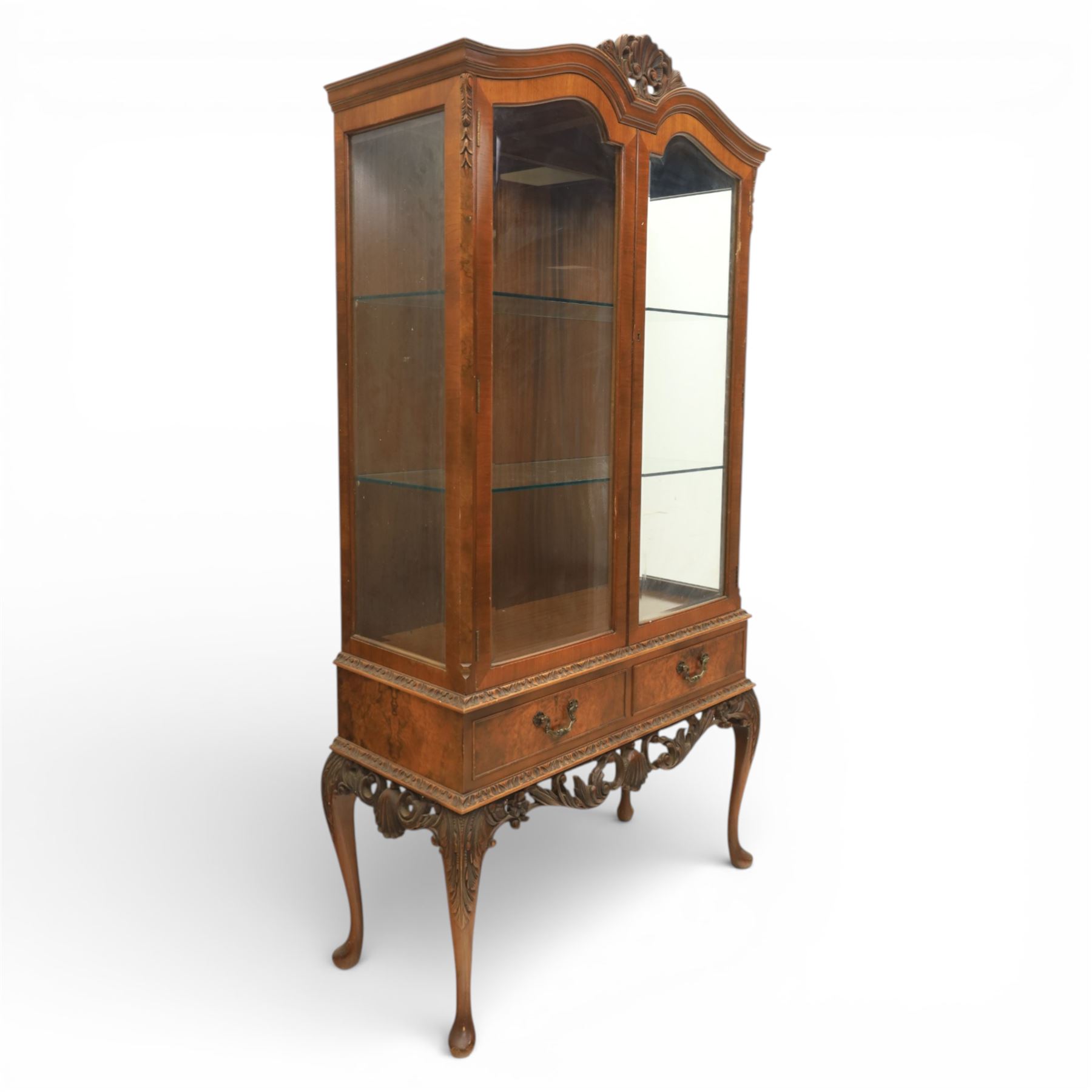 Queen Anne design walnut display cabinet, carved cartouche above two glazed doors enclosing two fixed glass shelves, over two frieze drawers above a heavily carved apron with cabriole supports