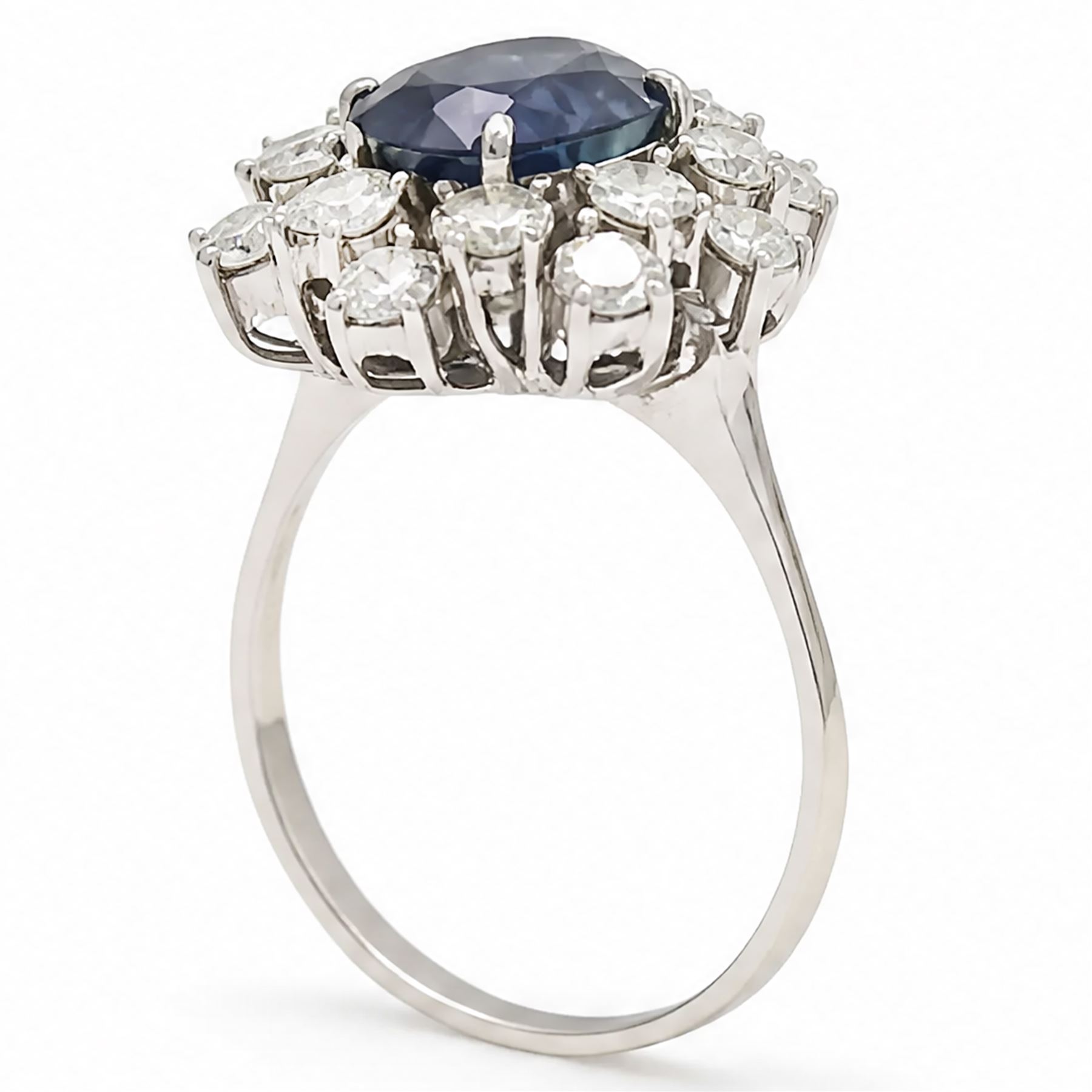 18ct white gold sapphire and diamond cluster ring, single oval cut sapphire of approx 2.10 carat, surrounded by sixteen round brilliant cut diamonds, total diamond weight approx 0.95 carat