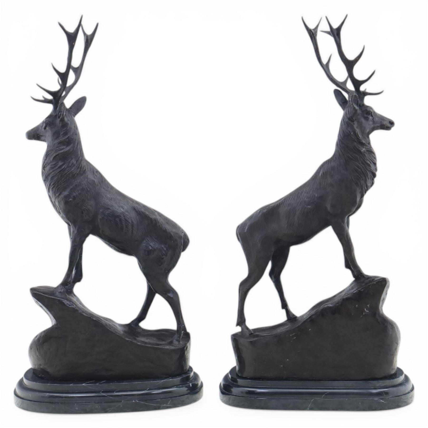 Pair of bronze stags, after Jules Moigniez, modelled in alert stance upon naturalistic bases, set on oval marble plinths, signed to base