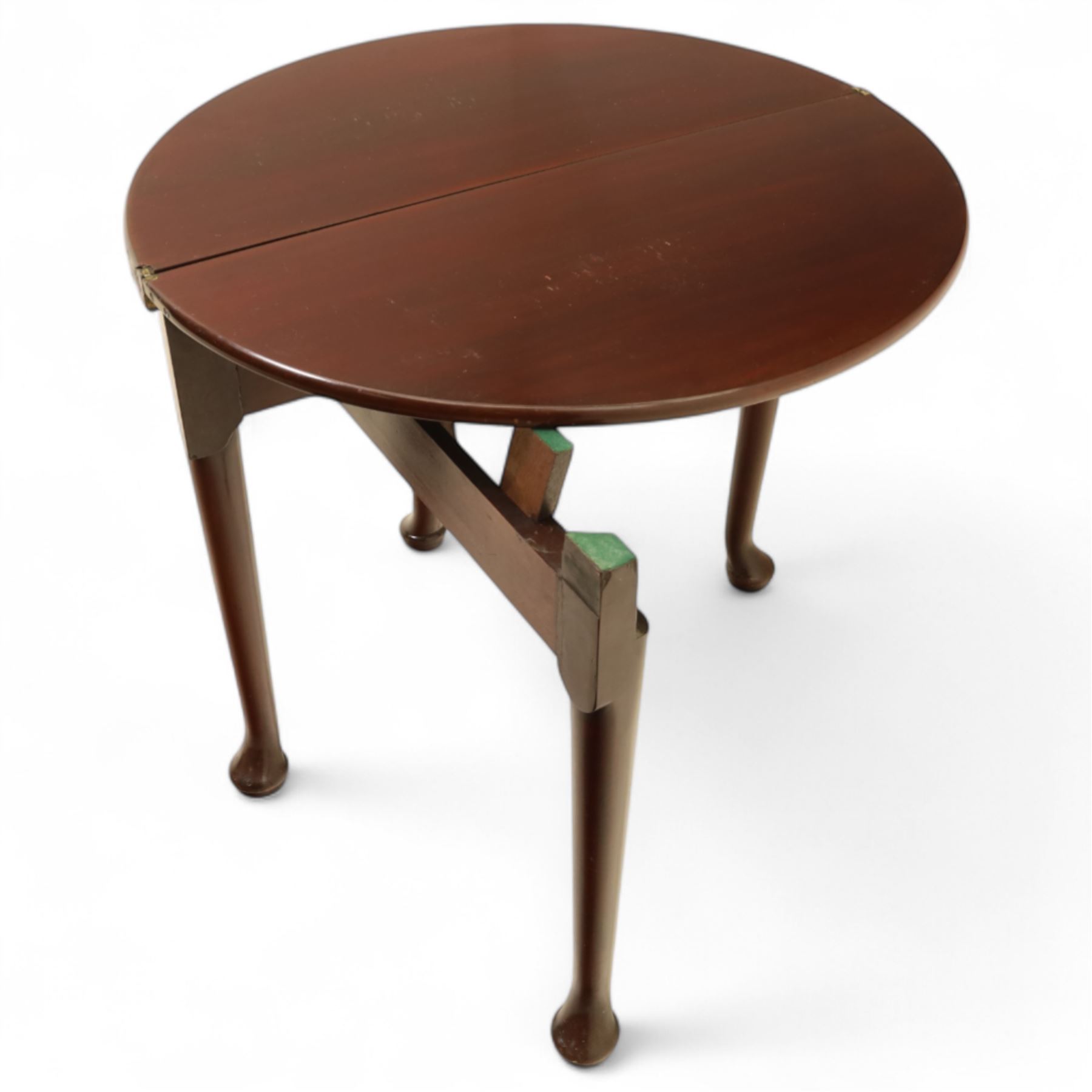 20th-century Georgian Revival style double fold-over card table, the first hinged circular top with polished mahogany surface above a second hinged circular top revealing a green baize playing surface with four counter-wells, underneath with a recessed compartment with and  chip and dice wells, the apron with fitted lock and key, raised on slender straight legs with pad feet 